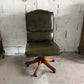 Dark green vintage armchair on wheels in imitation leather